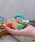 Nic organic grip car wooden baby toy placed on a child's hand.