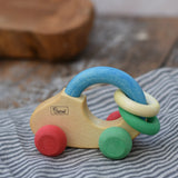 Nic organic grip car wooden baby toy placed on a striped grey cloth.