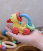 Nic organic grip duck wooden push along baby toy on a child's hand.