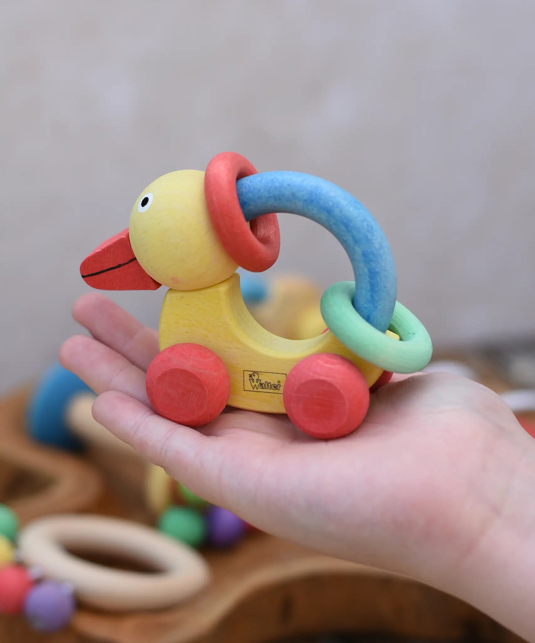 Nic organic grip duck wooden push along baby toy on a child's hand.