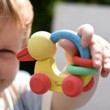 Nic organic grip duck wooden push along baby toy in a child's hand.