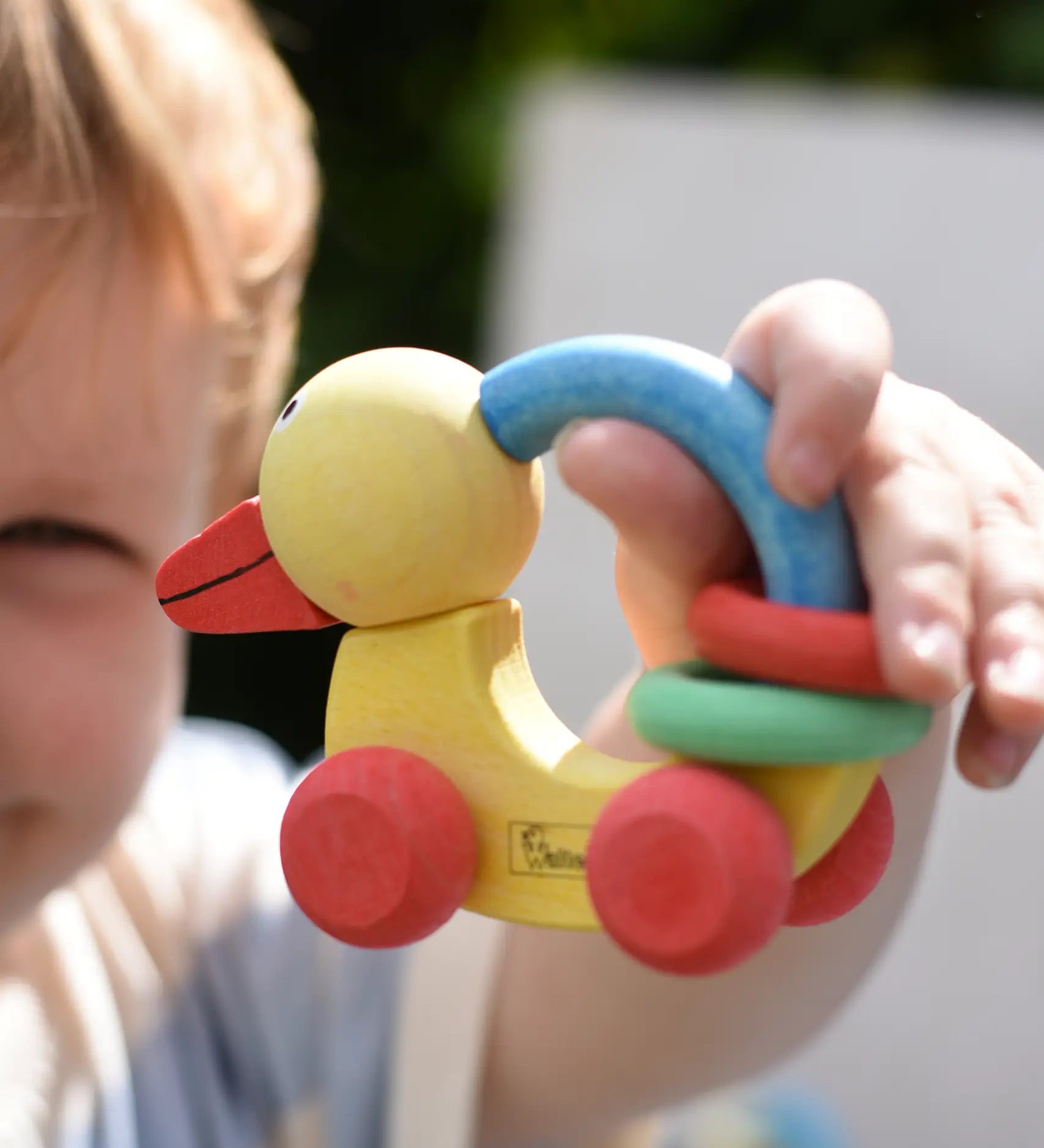 Nic organic grip duck wooden push along baby toy in a child's hand.