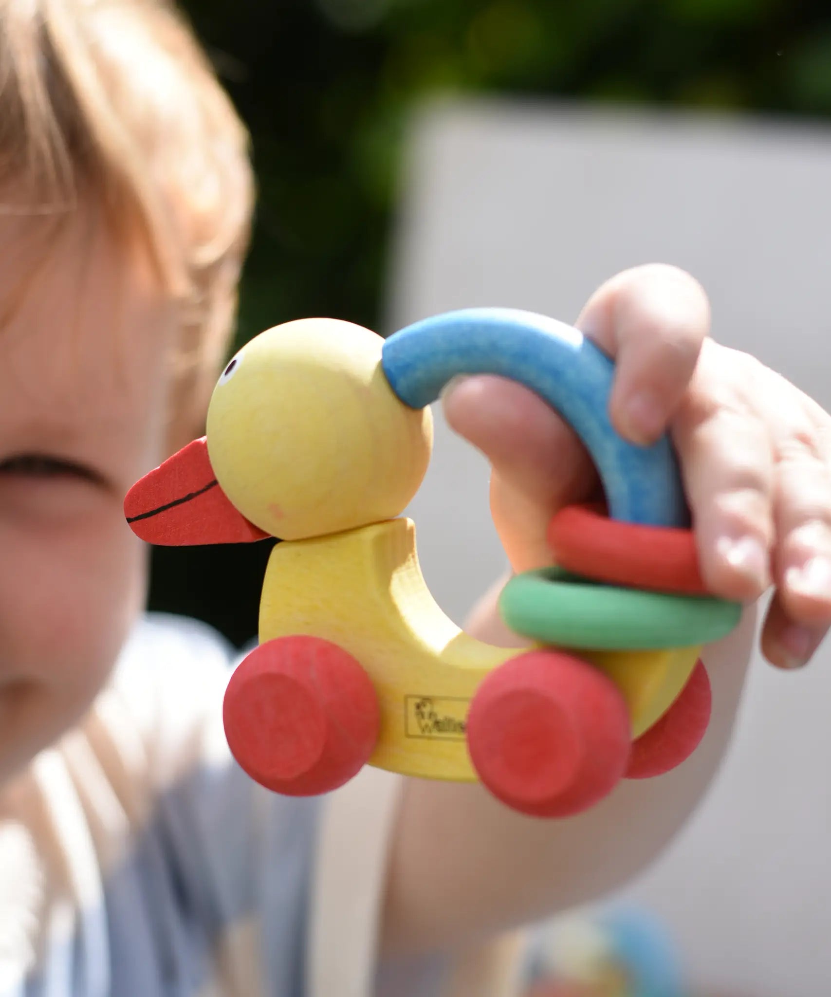 Nic organic grip duck wooden push along baby toy in a child's hand.