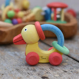 Nic organic grip duck wooden push along baby toy placed on a wooden surface.