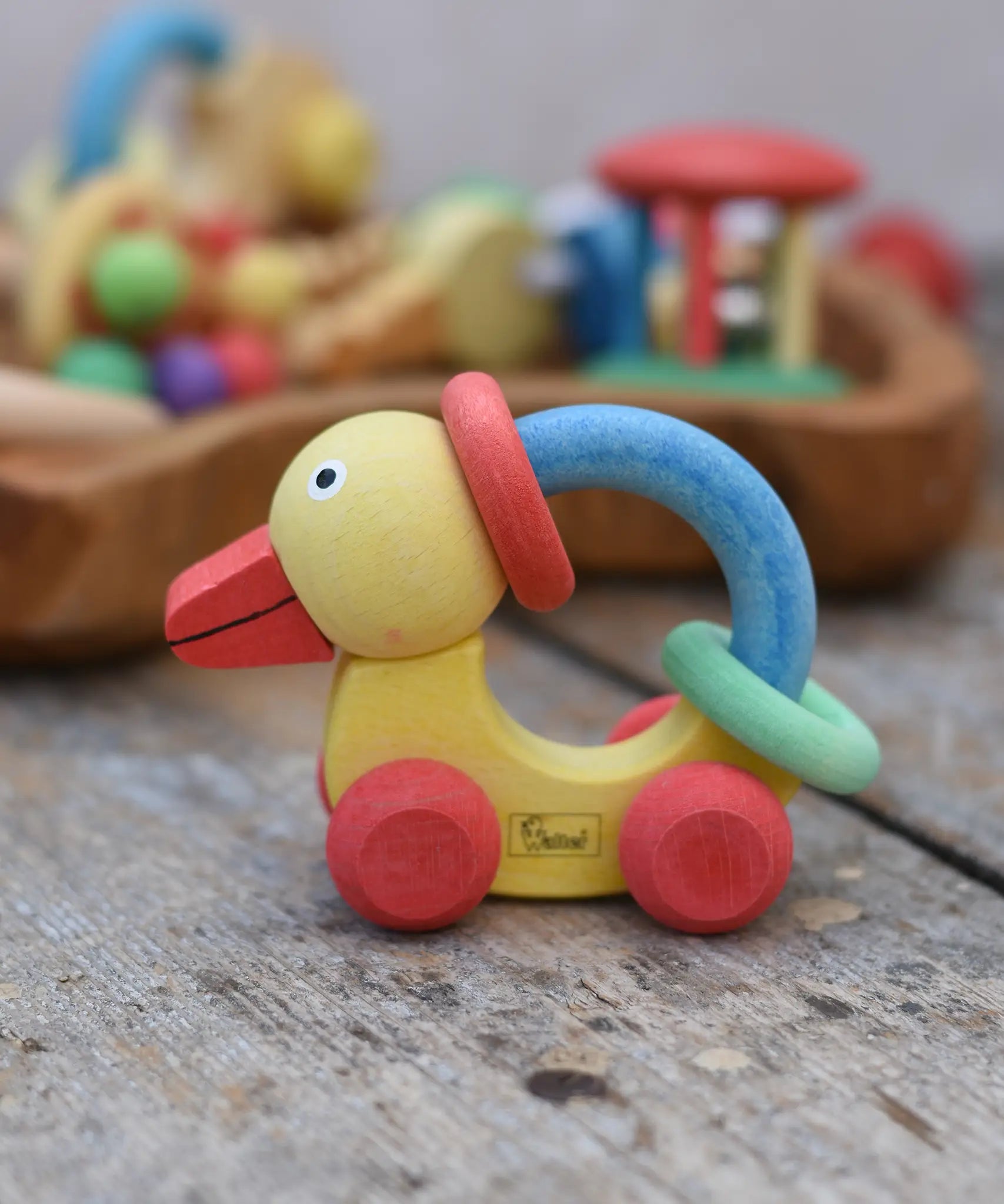 Nic organic grip duck wooden push along baby toy placed on a wooden surface.