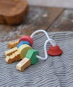 Nic organic wooden grasping keyring set placed on a grey striped cloth. 
