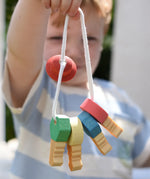 Nic organic wooden grasping keyring set in a child's hand. 
