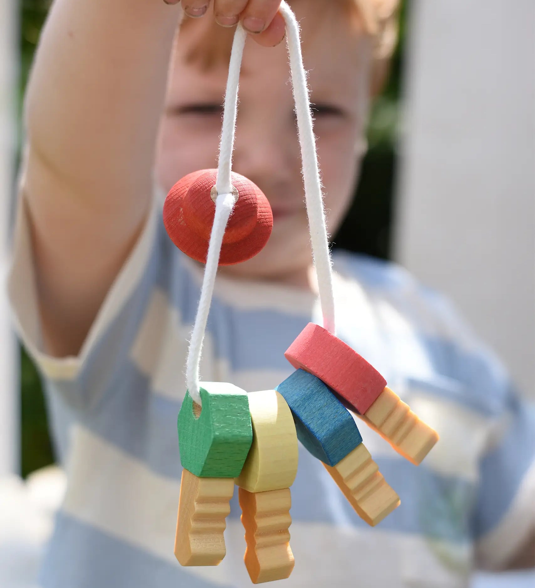Nic organic wooden grasping keyring set in a child's hand. 