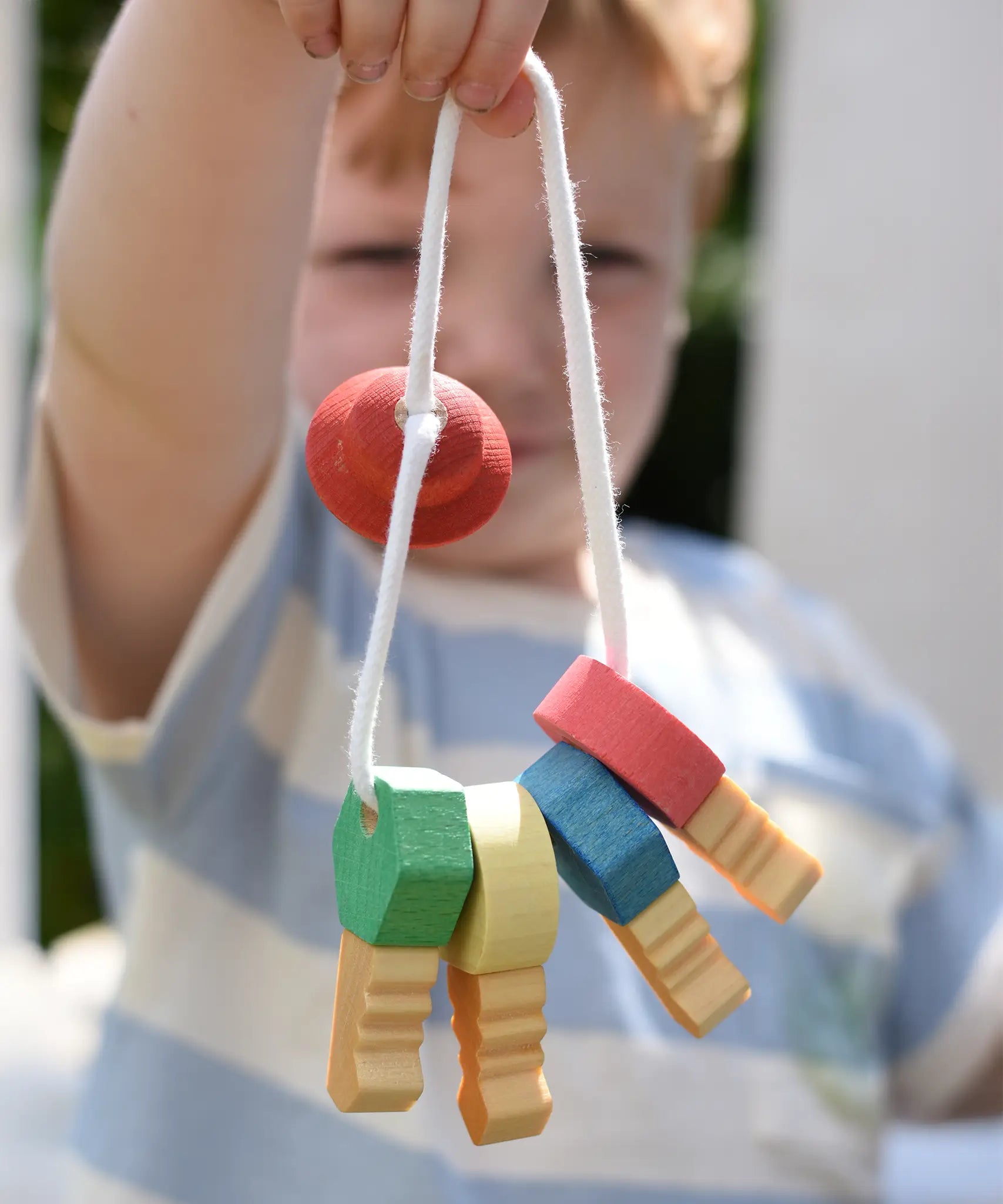 Nic organic wooden grasping keyring set in a child's hand. 