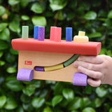 Nic Walter bio organic wooden pounding bench children's toy in a child's hand.