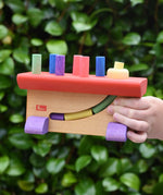 Nic Walter bio organic wooden pounding bench children's toy in a child's hand.