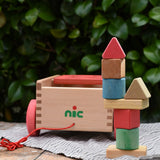Nic wooden carriage shape sorter pull along toy. 8 wooden blocks in various shapes and colours stacked into a tower.