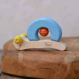 Nic snail baby grasping toy. A light wood and blee wooden toy snail with yellow beads for eyes and an orange bell. 
