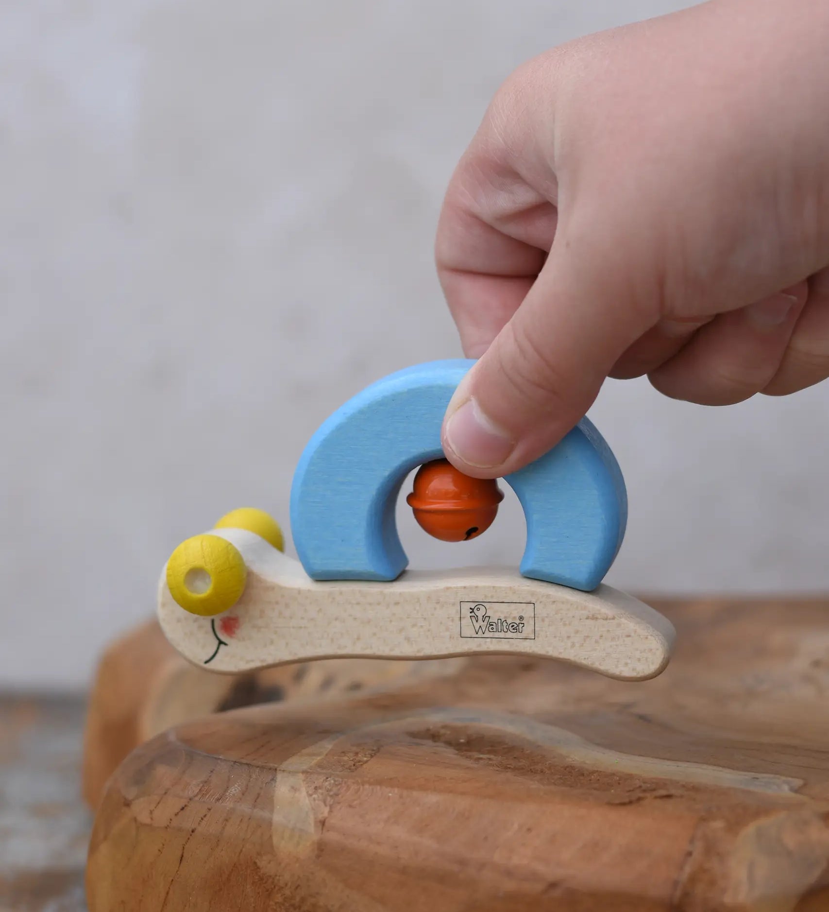 Nic snail baby grasping toy in a child's hand.