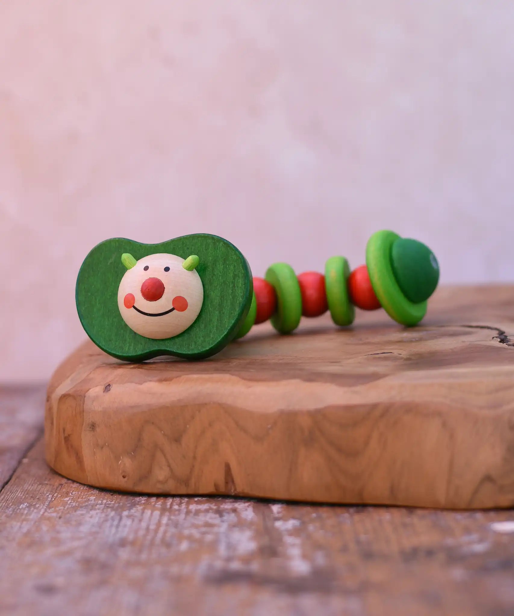 Nic apple worm baby wooden grasping toy. Smiling worm on a flexible rope lined with chunky red and green beads.