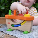Child placing a cylinder block piece into the slot on the Nic wooden pounding bench hammering toy. 