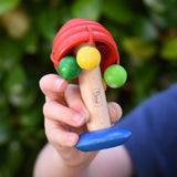 Nic mushroom wooden rattle toy in a child's hand.