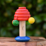 Nic mushroom wooden rattle baby toy placed on a wooden surface. 