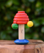 Nic mushroom wooden rattle baby toy placed on a wooden surface. 
