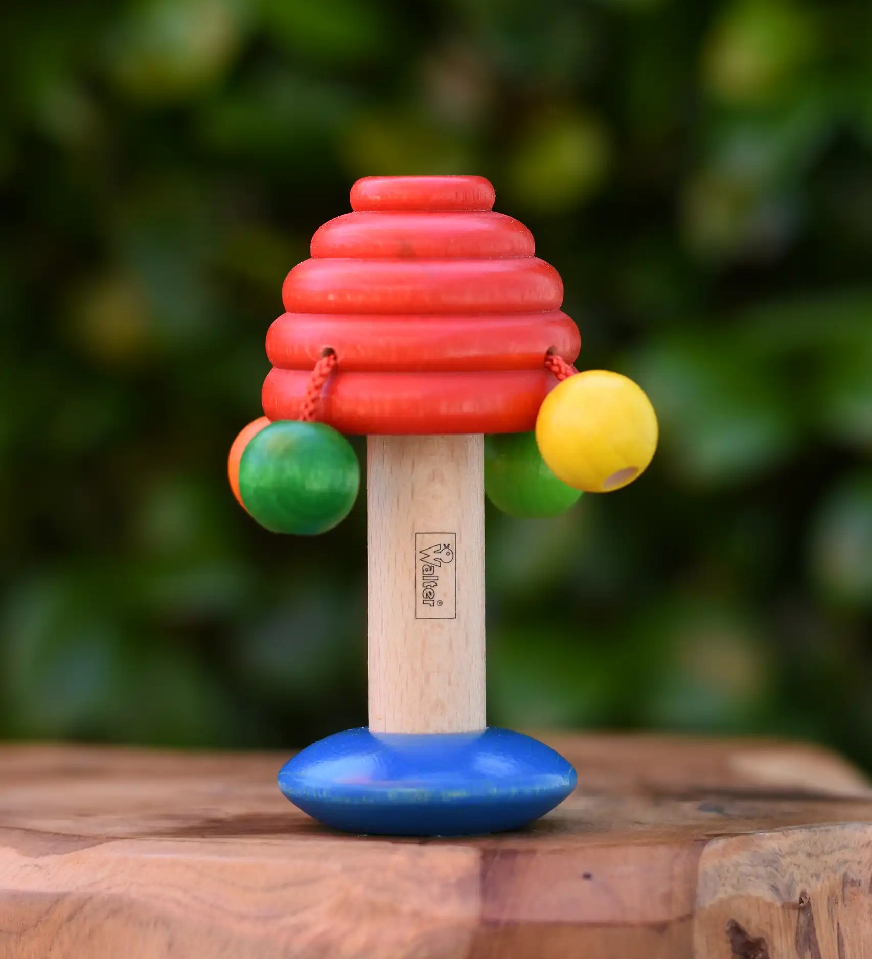 Nic mushroom wooden rattle baby toy placed on a wooden surface. 
