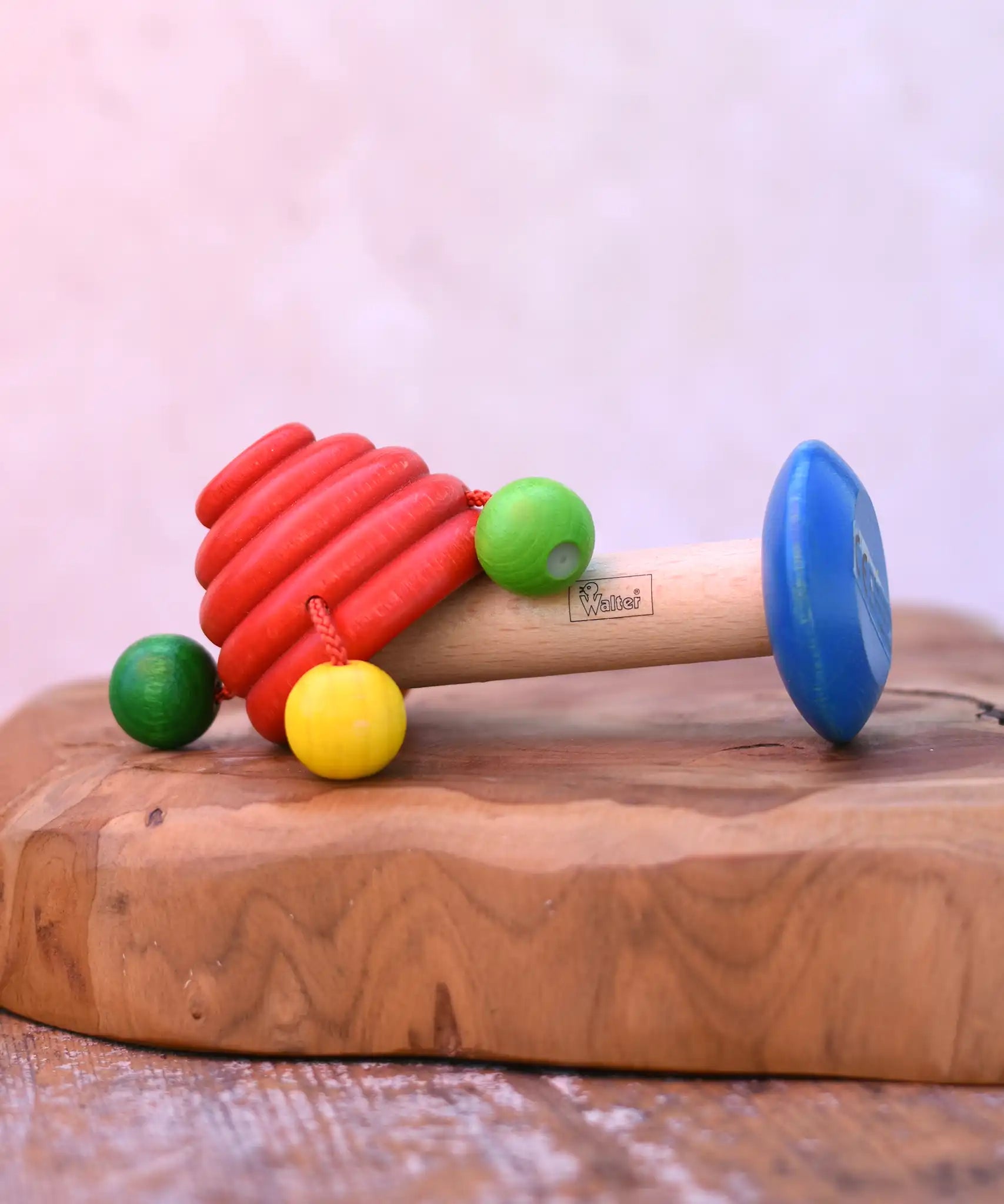 Nic mushroom wooden rattle toy placed on a wooden surface. 