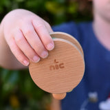 Nic Toys wooden rolling rattle in a child's hand. Roll along rattle with multicoloured beads.