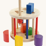 Nic Toys rolling sorter. Features different coloured wooden blocks in different shapes to fit in the cut out holes on the roller with a opening for easy access