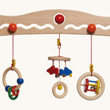 A close up of the 3 grasping toys attached the the Nic Toys wooden baby trainer. Graspers are a mix of rattles and  can be swapped over or taken off 