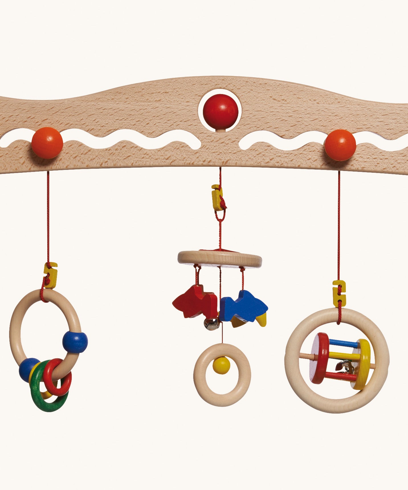A close up of the 3 grasping toys attached the the Nic Toys wooden baby trainer. Graspers are a mix of rattles and  can be swapped over or taken off 