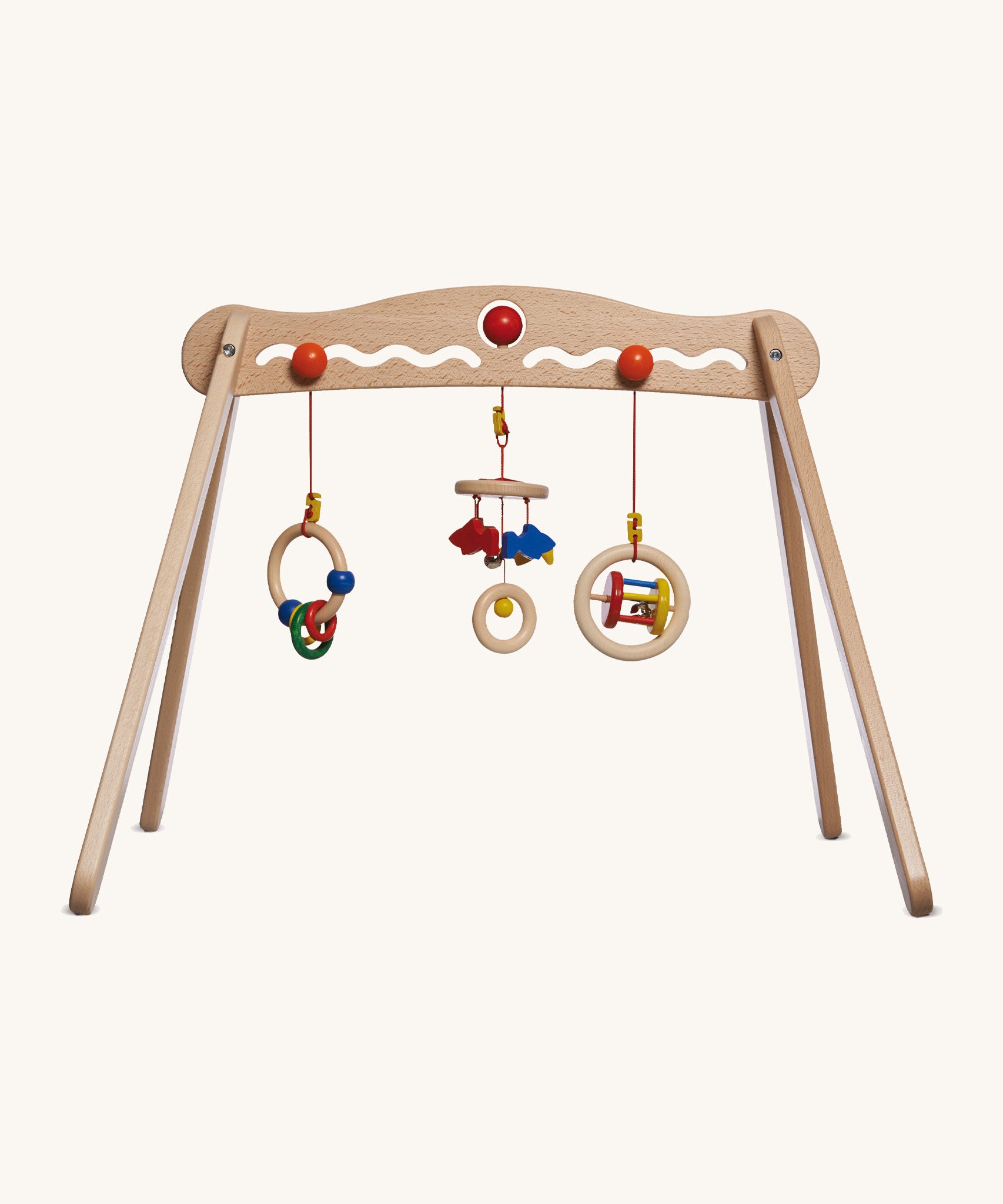 A Nic Toys wooden baby trainer available at Babipur. Features 3 grasping toys that can be swapped over  and hangs above when a baby is lying underneath