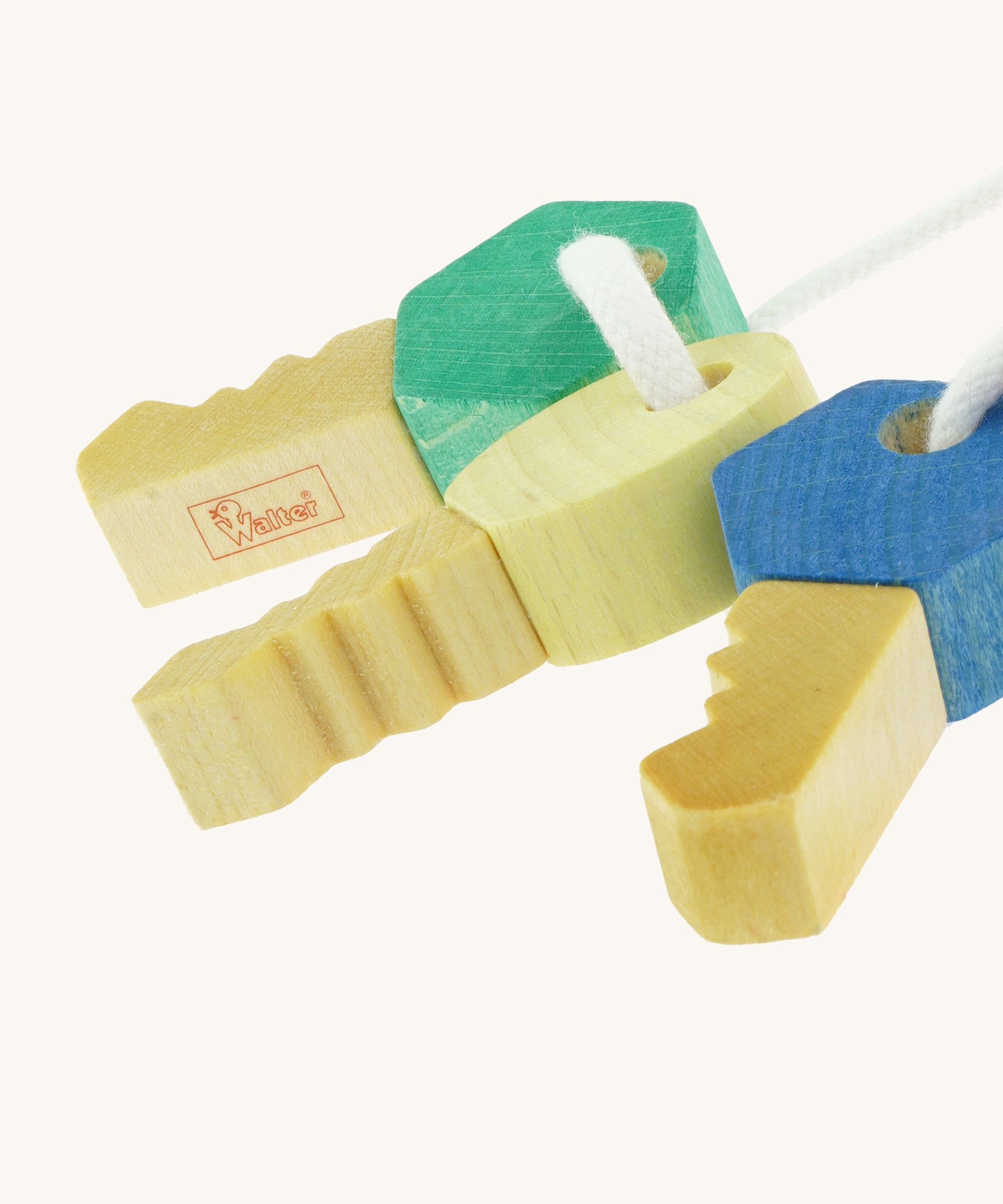 A close up of the Nic Toys wooden grasping keyring set available at showing the cut detail on the keys and brand logo