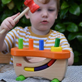 Child hammering the cylinder pieces into the Nic wooden pounding bench hammering toy.
