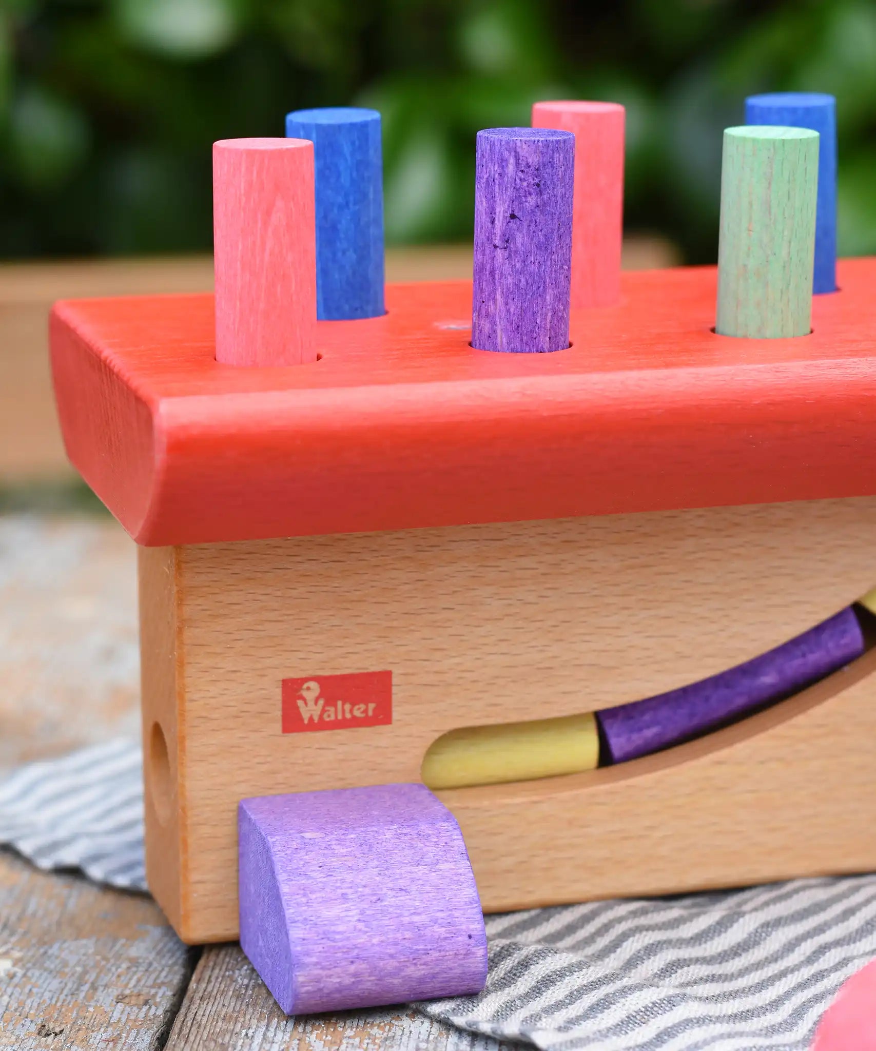 Close up of the Walter logo on the side of the Nic Walter bio organic wooden pounding bench children's toy.