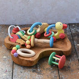 Collection of Nic organic wooden baby toys placed on a wooden dish. Wooden baby toys perfectly sized for little hands to grasp. 