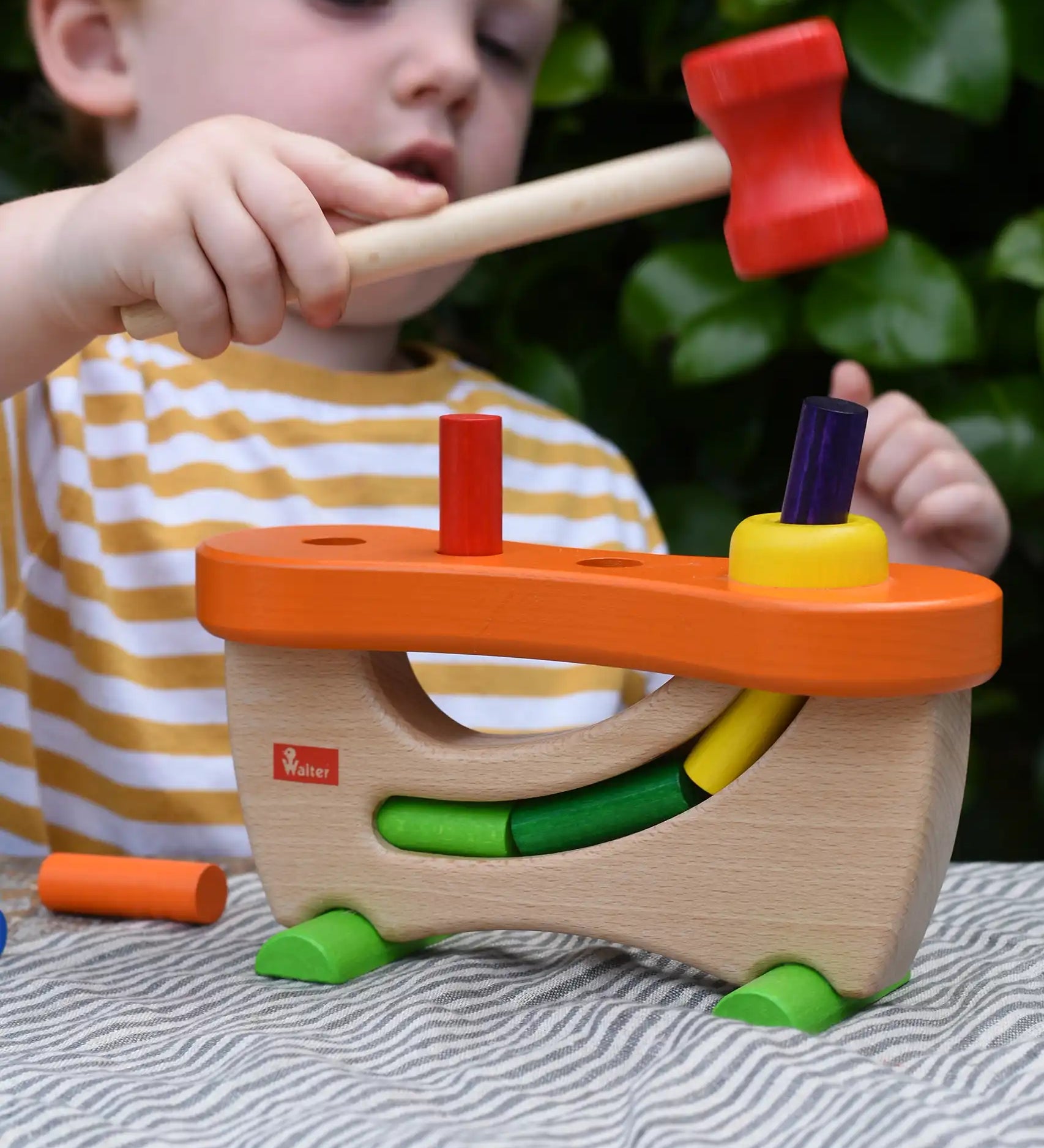 Child playing with the Nic wooden pounding bench hammering toy.