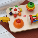 Close up of the spinning carousel top and squeak button attached to the Nic Wooden Baby Game busy Board with 4 four activities.