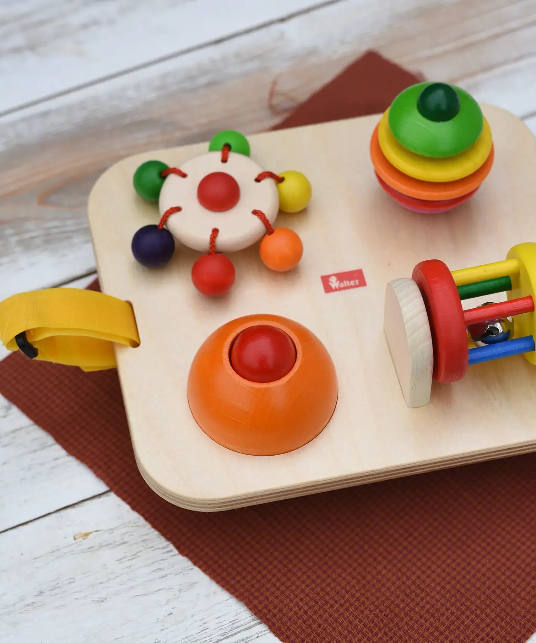 Close up of the spinning carousel top and squeak button attached to the Nic Wooden Baby Game busy Board with 4 four activities.