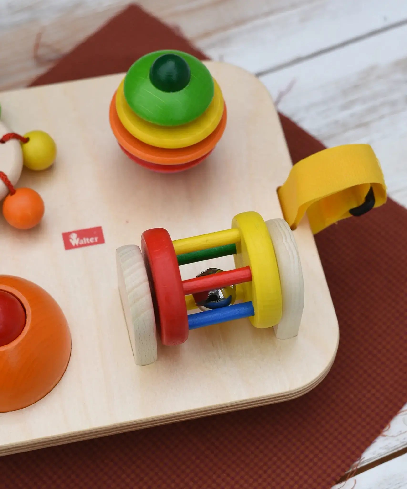 Close up of the rattling tree top and roller attached to the Nic Wooden Baby Game busy Board with 4 four activities.