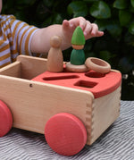 Nic wooden carriage shape sorter pull along toy with Grapat toys placed on top, Nins, coins and rings.