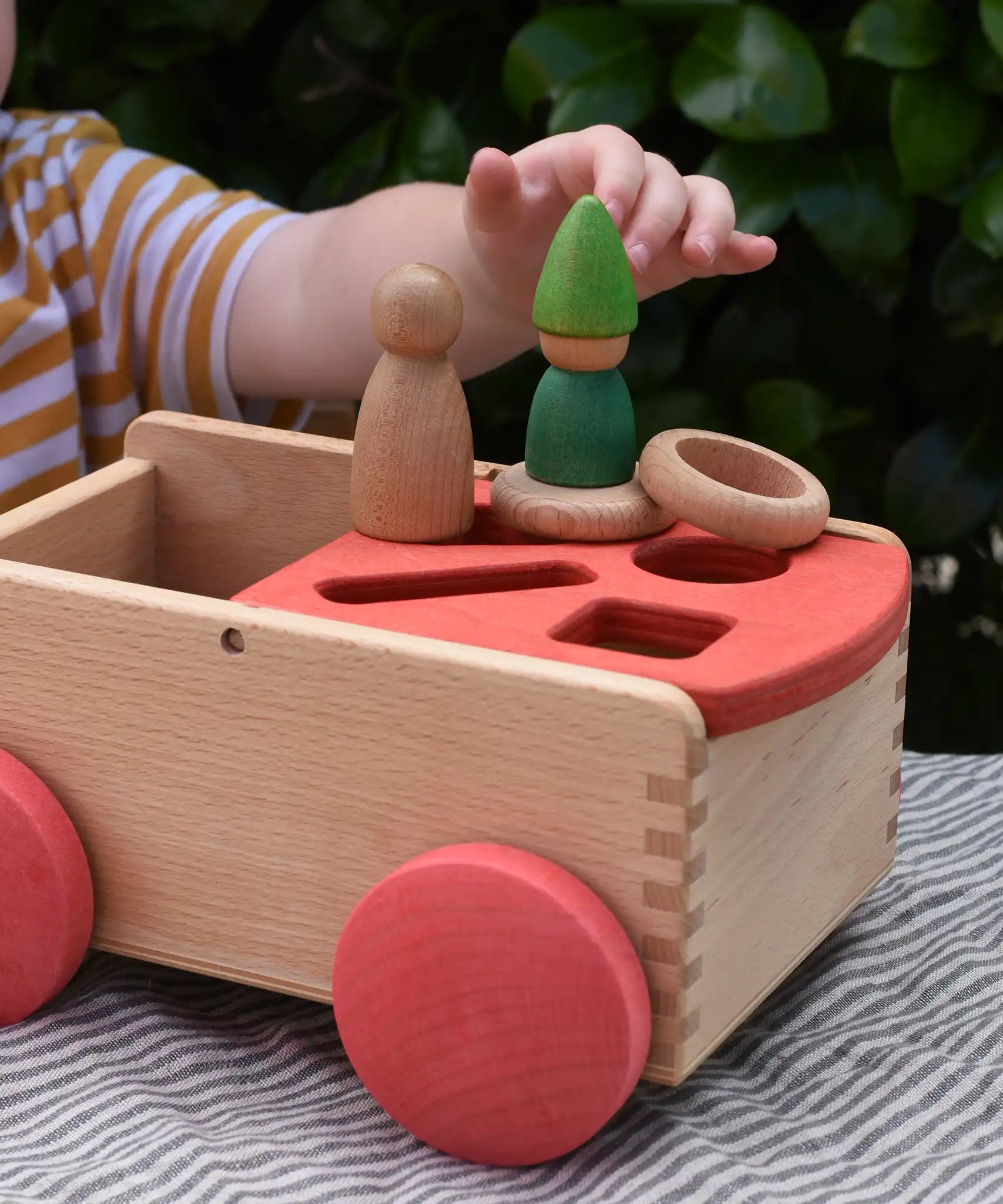 Nic wooden carriage shape sorter pull along toy with Grapat toys placed on top, Nins, coins and rings.