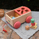 Nic wooden carriage shape sorter pull along toy. 8 wooden blocks in various shapes and colours.