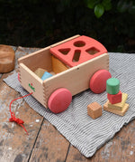 Nic wooden carriage shape sorter pull along toy. 8 wooden blocks in various shapes and colours.