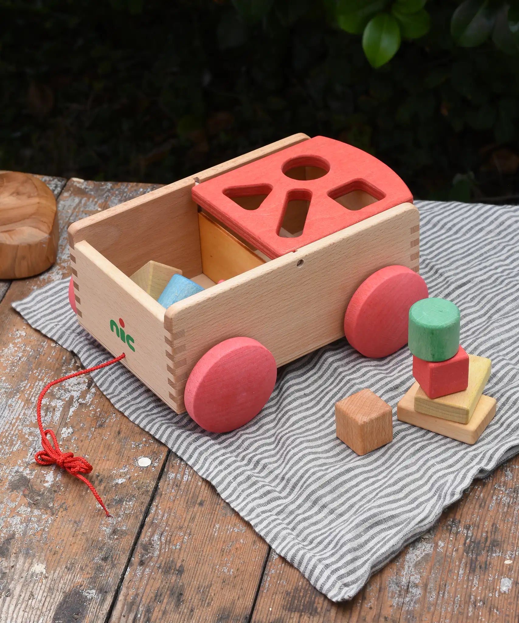 Nic wooden carriage shape sorter pull along toy. 8 wooden blocks in various shapes and colours.