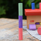 Three cylinder blocks from the Nic Walter bio organic wooden pounding bench children's toy stacked on top of each other.