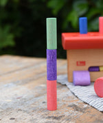 Three cylinder blocks from the Nic Walter bio organic wooden pounding bench children's toy stacked on top of each other.