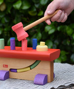 Child's hand holding the hammer rom the Nic Walter bio organic wooden pounding bench children's toy.