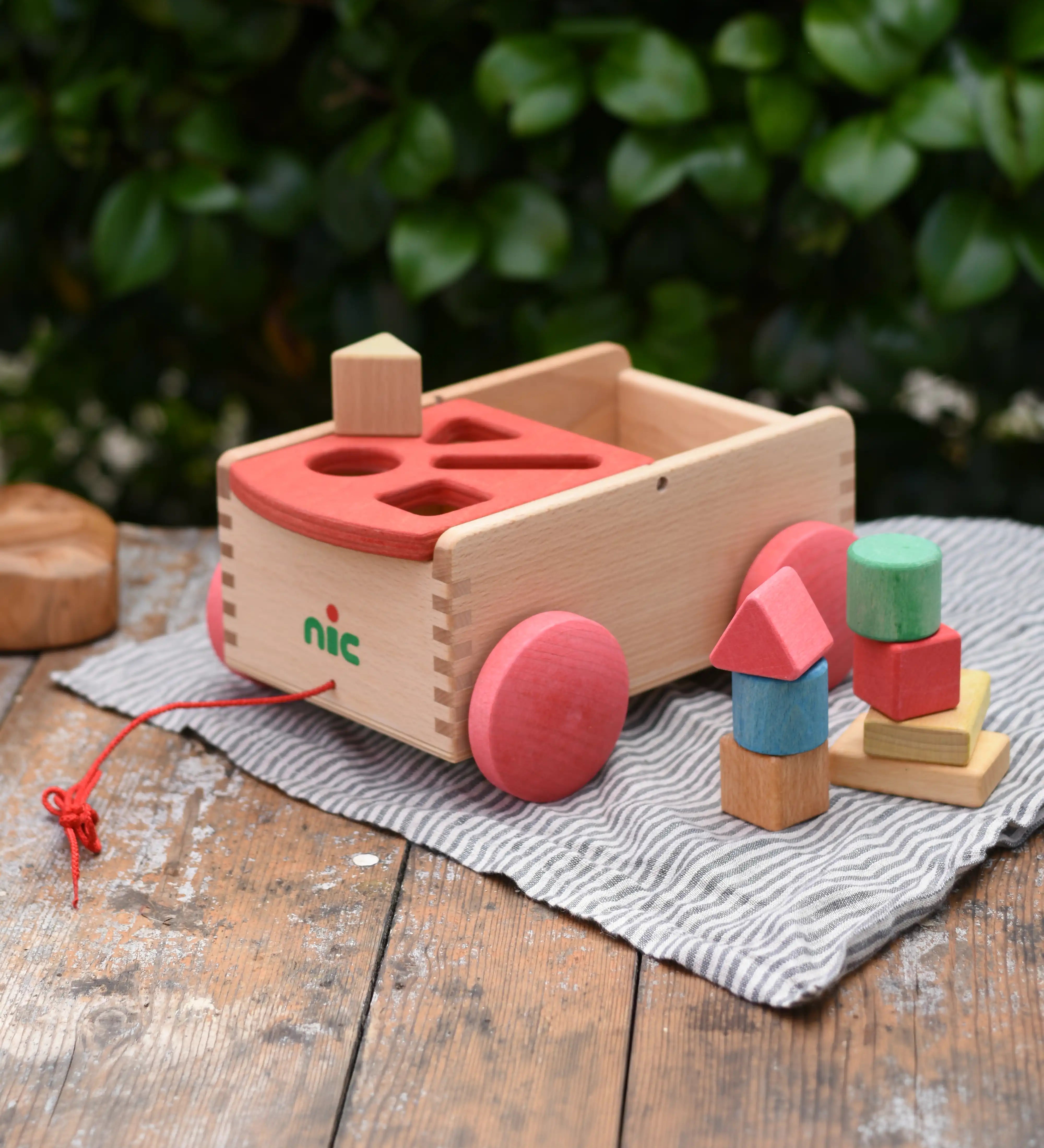 Nic wooden carriage shape sorter pull along toy. 8 wooden blocks in various shapes and colours.