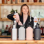 Woman leaning at a bar behind a row of assorted One Green Bottle 2 litre eco-friendly water bottles