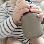 Close up of childs hands clutching the One Green Bottle eco-friendly metal water bottle 