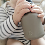 Close up of childs hands clutching the One Green Bottle eco-friendly metal water bottle 